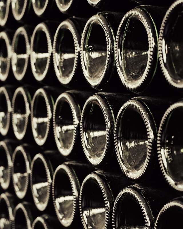 Bottles stacked on their sides, punts outwards, ageing on their lees.