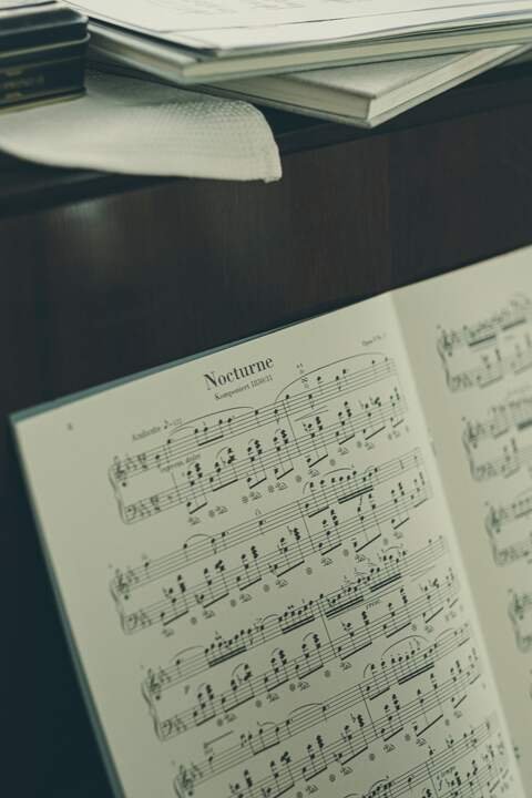 A nocturne open on the piano, the page lit from the window.