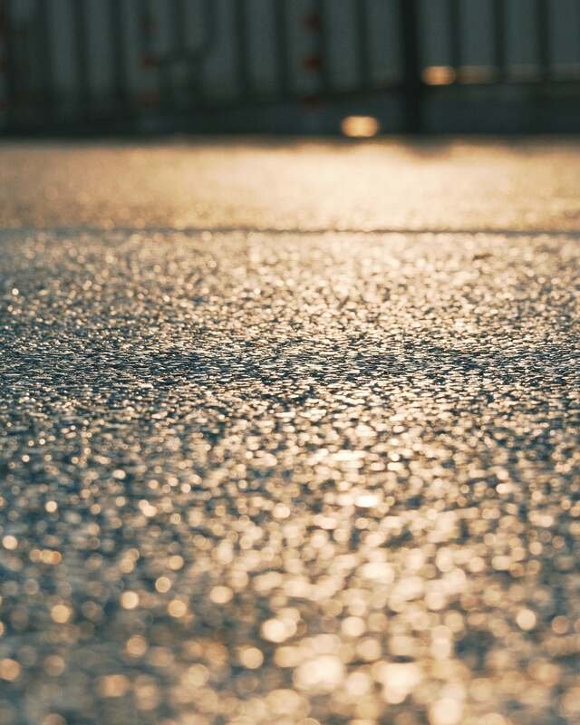 Salt crystals and wet pavement catching the light at ground level.