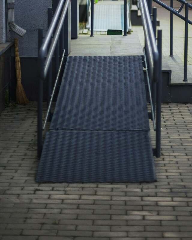 An accessible ramp and steps at a building entrance, cleared and dry.