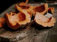 Wedges of orange squash on an old board.