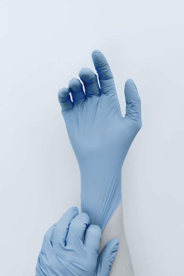 A second pair of gloves pulled on over the cuff before entering the filling room.