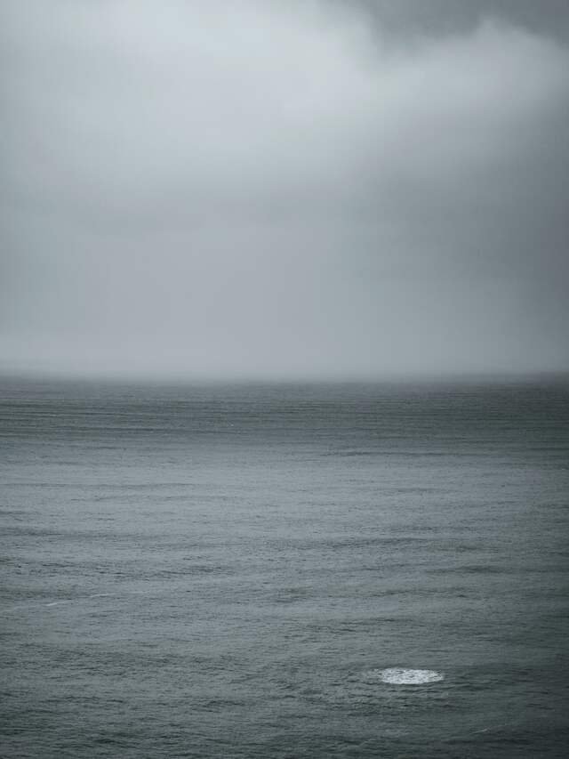 The sea under a heavy grey sky, a squall darkening the horizon.