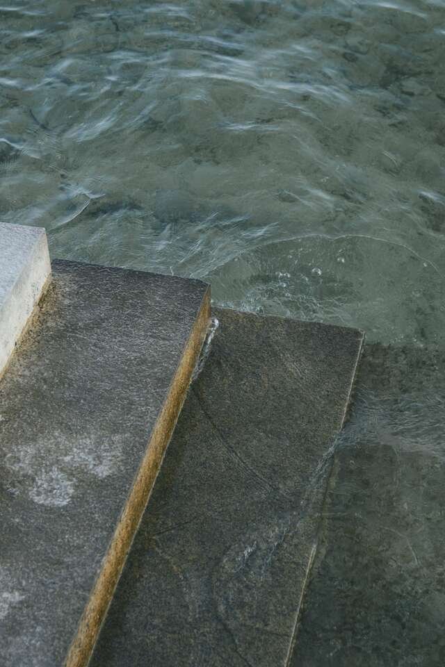 Worn stone steps leading down into clear, green, cold water.