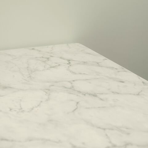 The honed edge of a white marble worktop with soft grey veining.